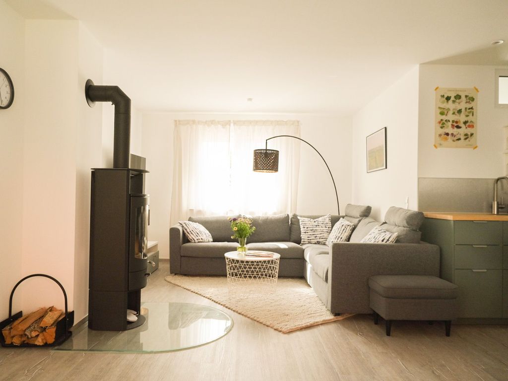 Wohnküche mit großem Ecksofa und Kamin.