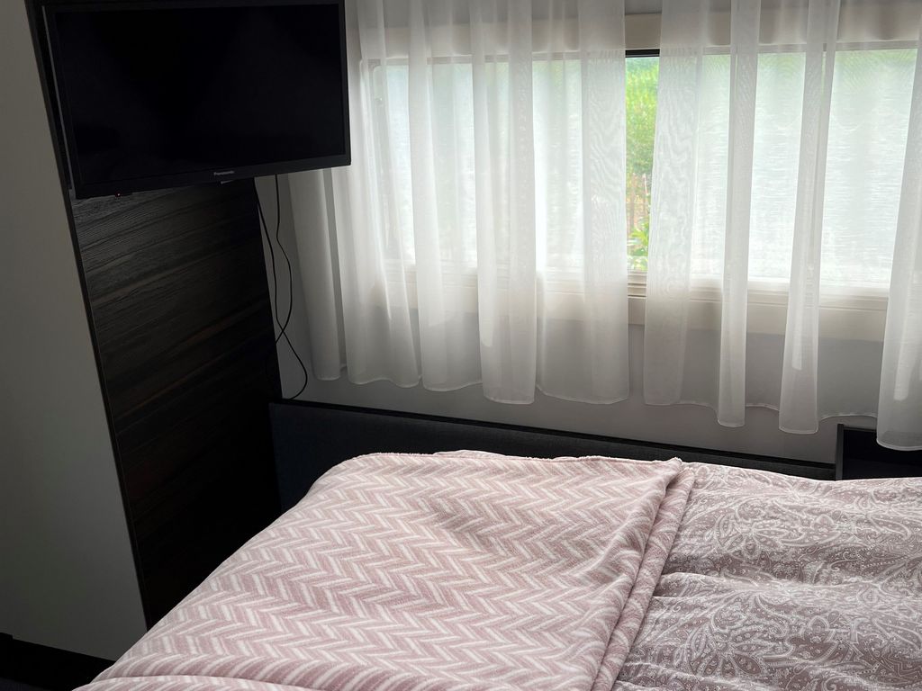 Schlafbereich mit Doppelbett und TV
