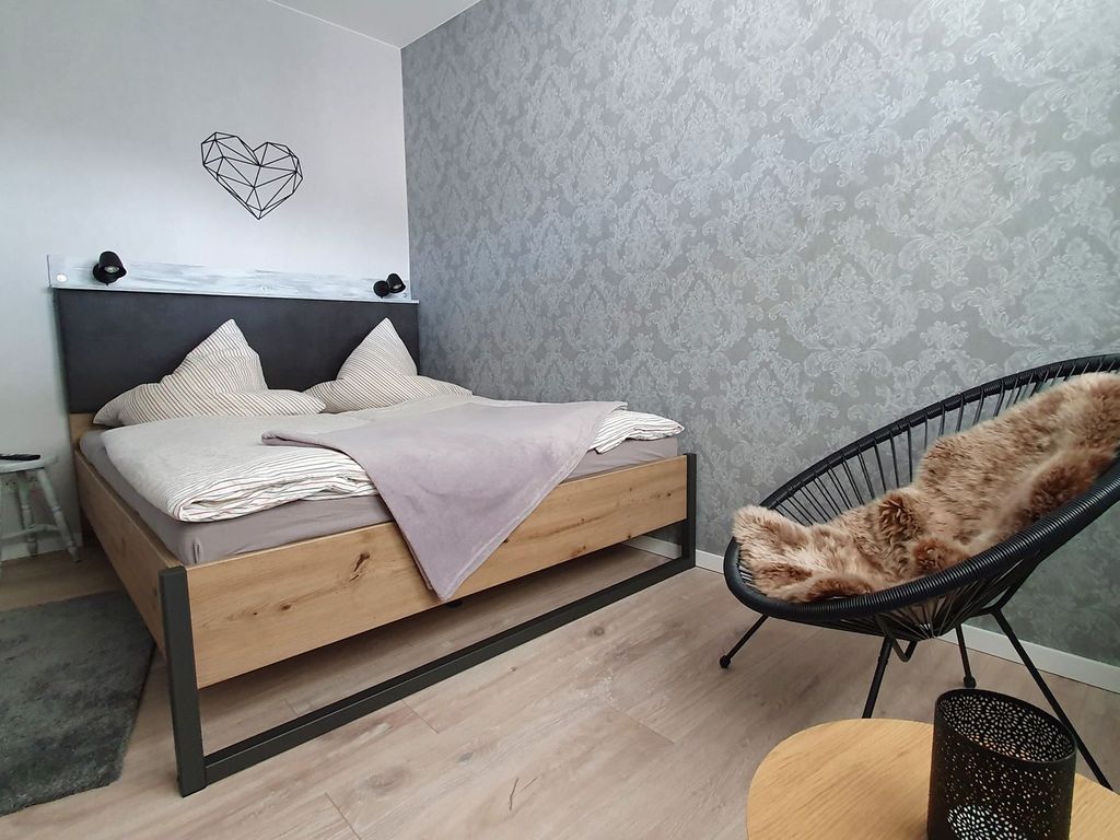 Schlafzimmer mit Doppelbett und Sitzgelegenheit