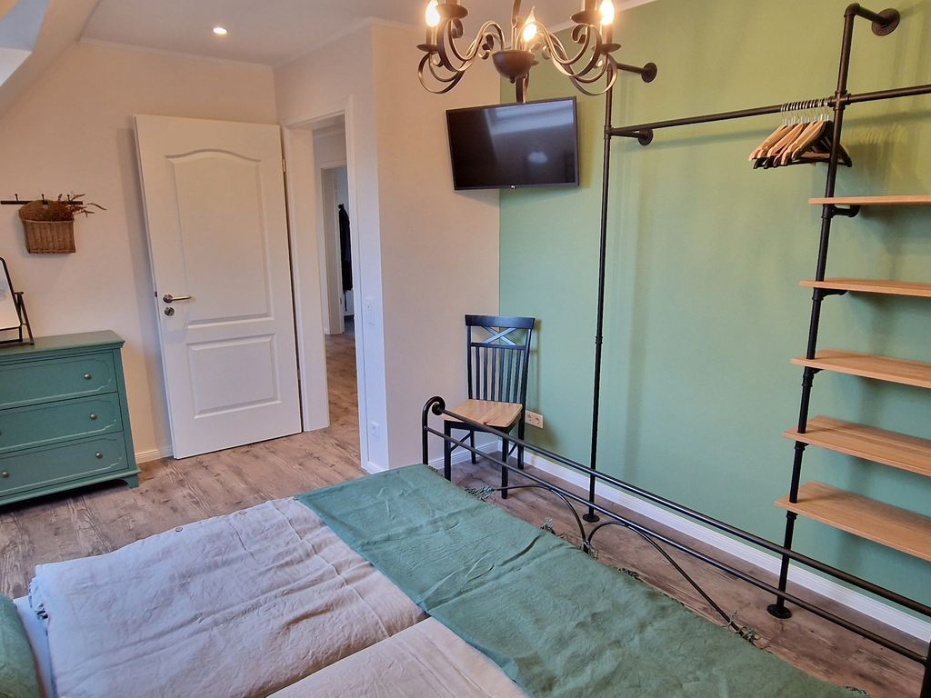 Schlafzimmer mit Doppelbett und TV