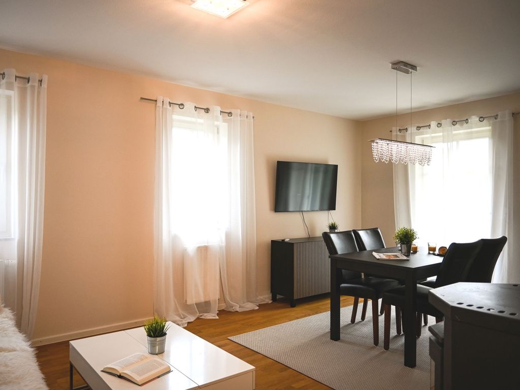 Wohnzimmer mit Esstisch, TV und Zugang zur Terrassee