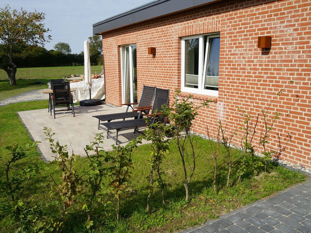 Terrasse mit Sitzmöbeln und Sonnenliegen