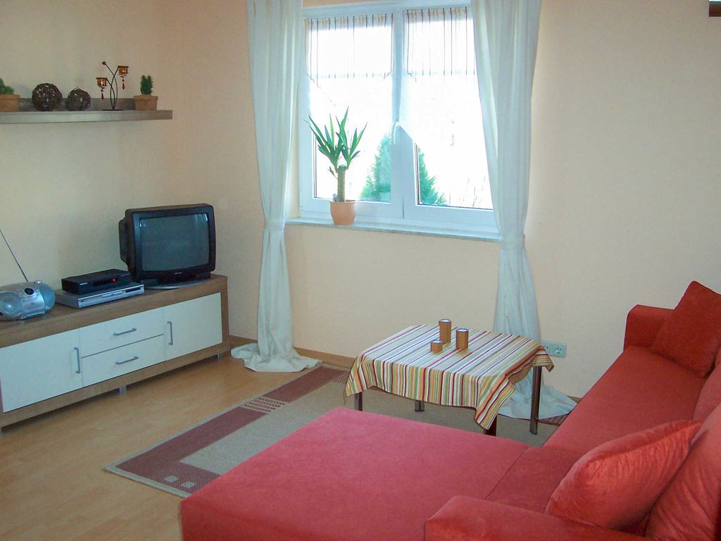 Wohnraum mit Schlafcouch und TV