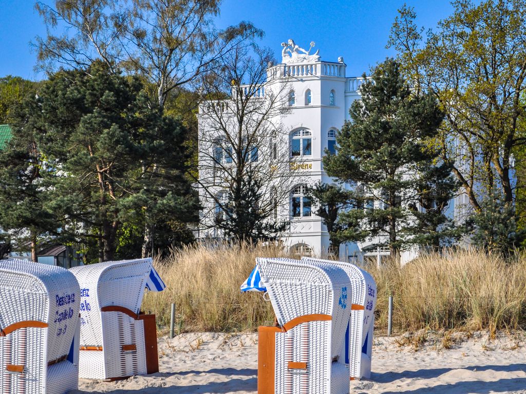 Villa Sirene Binz – Blick vom Strand über die Strandkörbe auf die Villa hinter den Kiefern