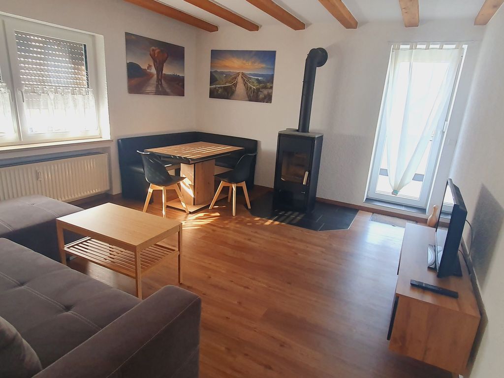 Wohn-/ Esszimmer mit Schlafsofa und Zugang zum Balkon