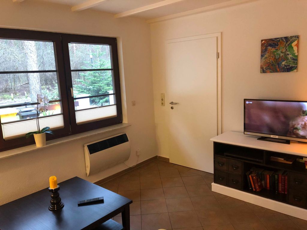 Das Ferienhaus Dünenwald 2 in Karlshagen auf Usedom - 
Das gemütliche Wohnzimmer mit einer bequemen Sitzgarnitur und Tisch lädt zu geselligen Spieleabenden oder entspannten Stunden beim Fernsehen ein.
