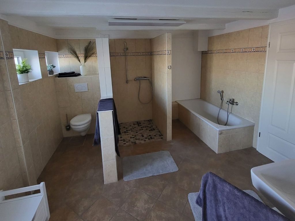 Großes Badezimmer mit ebenerdiger Dusche und Badewanne