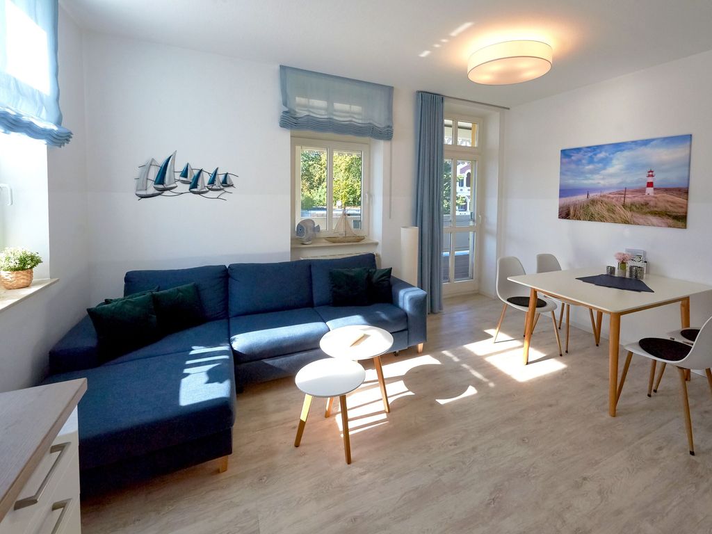 Villa Freya Sellin – überdachter Villenbalkon mit Korbmöbeln und Blick über das Villenviertel