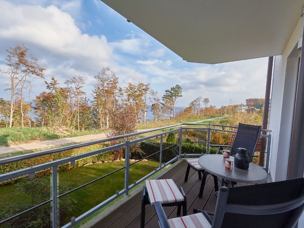 Residenz Falkenberg Sellin – heller Wohn-Essbereich einer Ferienwohnung mit Sitzgruppe und Esstisch
