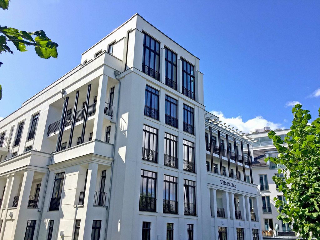 Villa Philine Sellin – offener Wohn-Essbereich mit Parkett, Designermöbeln und bodentiefen Fenstern