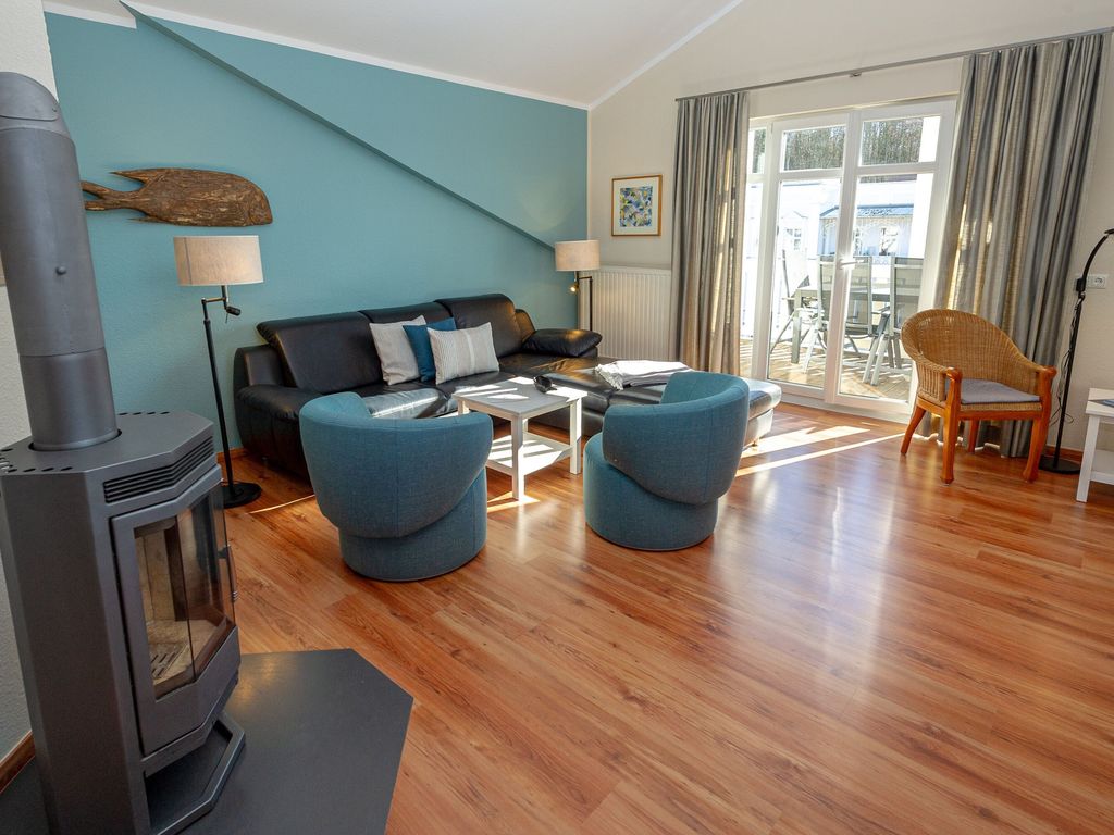 Villa Seerose Sellin – Wohnzimmer im Penthouse mit Kaminofen, Dachschräge und Zugang zur Dachterrasse