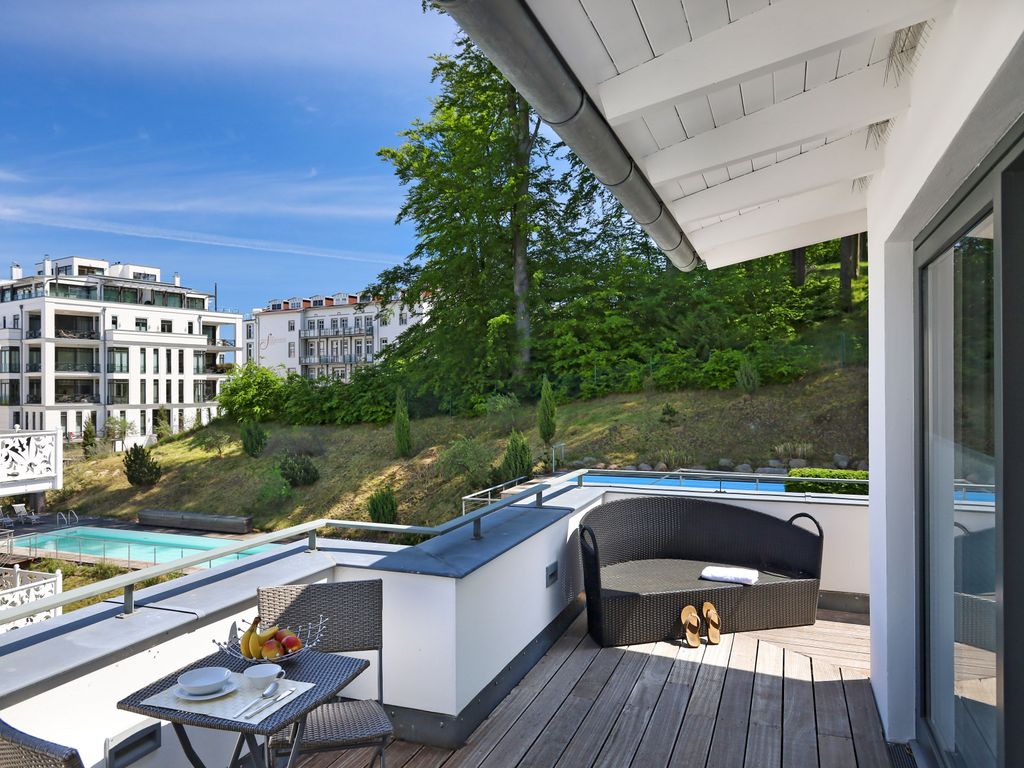 Villa Paula Sellin – Dachterrasse mit Loungemöbeln, dahinter Pool und bewaldeter Hang