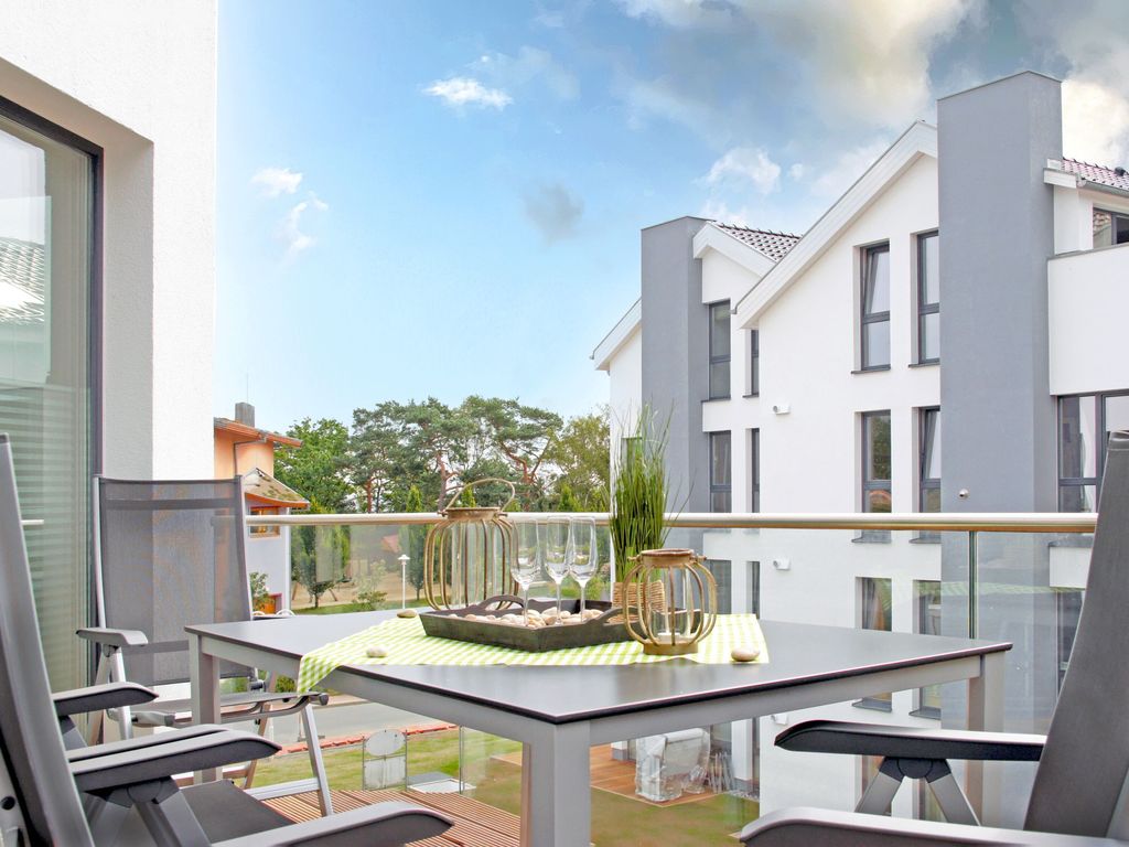 Strandvilla Baabe – möblierter Balkon mit Blick auf das Nachbarhaus und die Bäume des Kurparks
