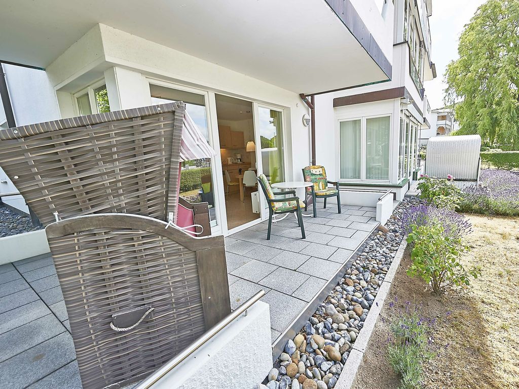 Villa Seerosen Binz – ebenerdige Terrasse mit Strandkorb, Sitzgruppe und Lavendelbeet am Garten