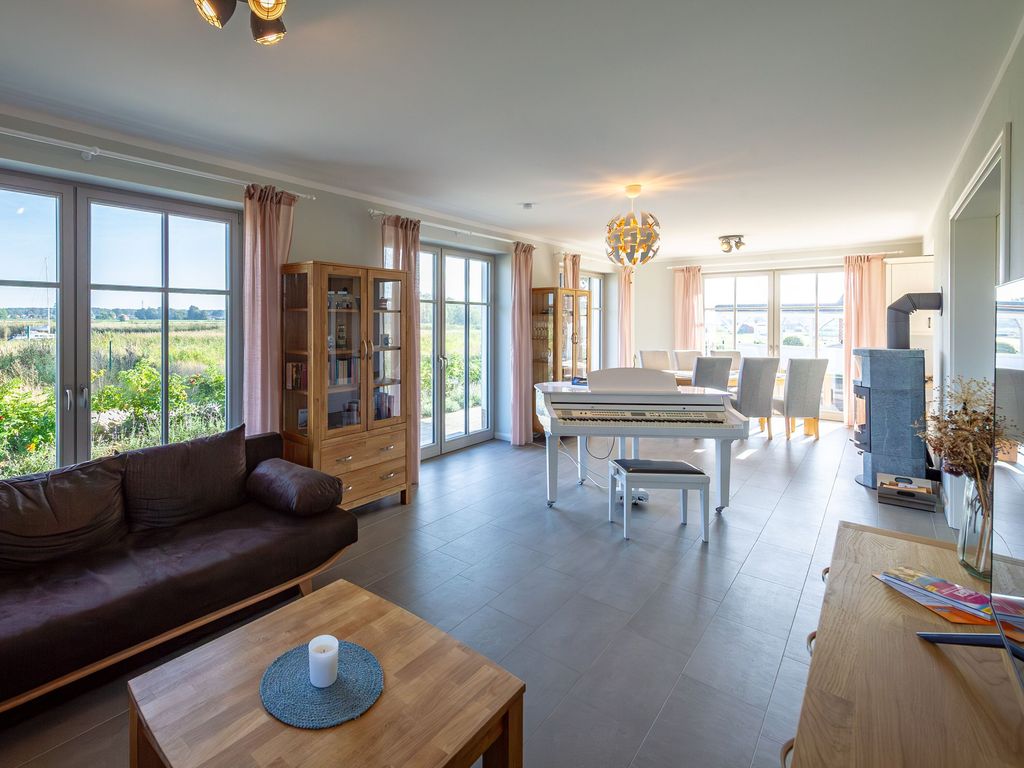 Offenes Wohnzimmer mit Klavier und Panoramablick auf die Landschaft