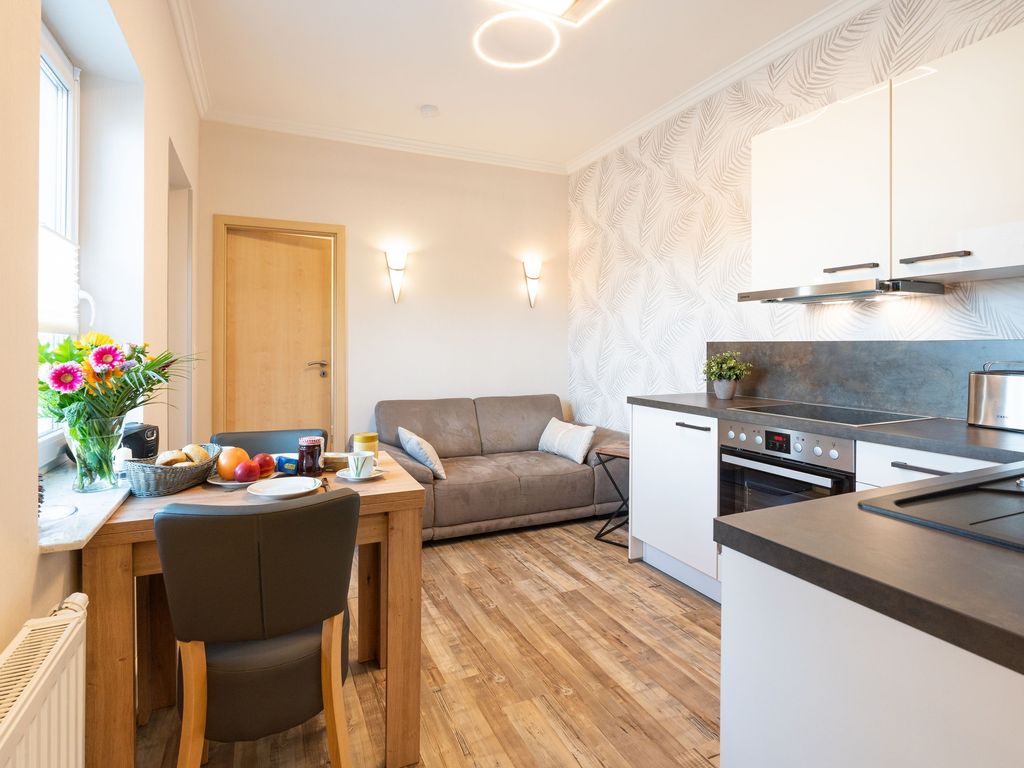 Wohnzimmer mit offener Küche und Essbereich