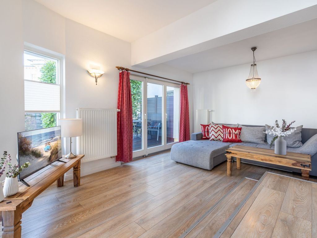 Wohnzimmer mit komfortablem Sofa und Flat-TV