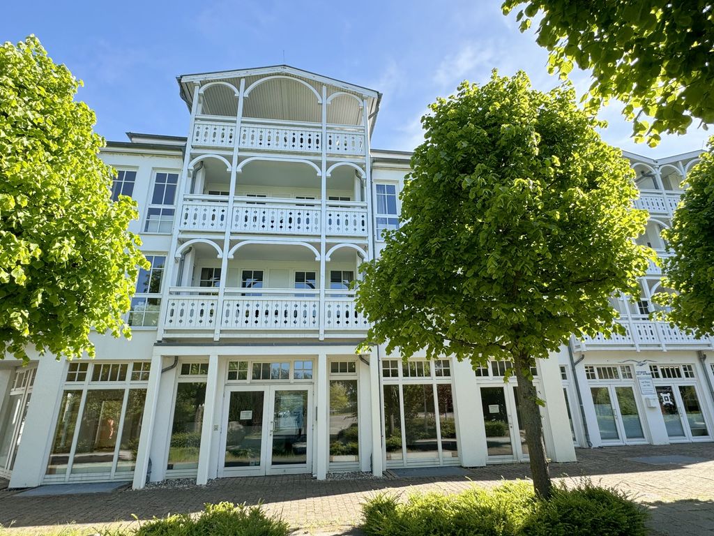 Seepark Sellin: weißes Haus in Bäderarchitektur mit Holzbalkonen und Loggien