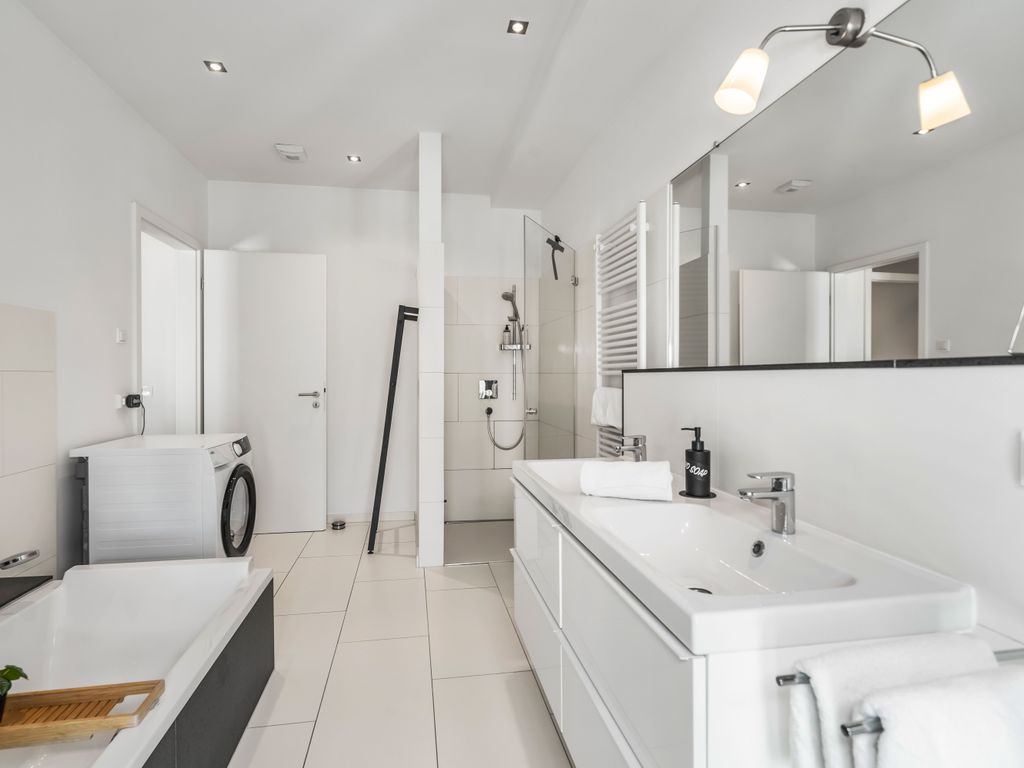 Großes Badezimmer mit Doppel-Waschbecken, Toilette, Badewanne, Dusche, Trockner,  Duschgel, Shampoo, Conditioner, Fön sowie eine Auswahl an Kosmetikartikeln steht für dich bereit.