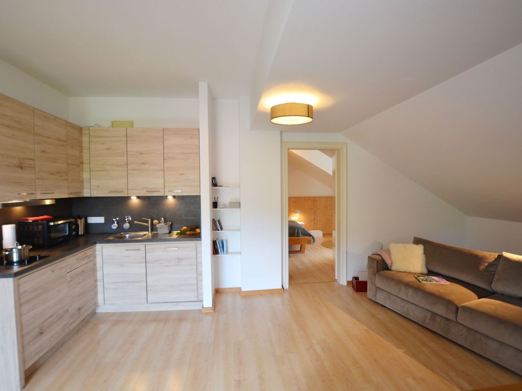 Wohnbereich mit offener Küche sowie Blick ins Schlafzimmer