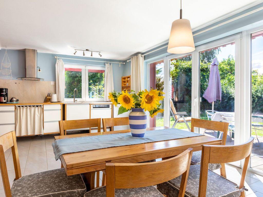 Heller offener Wohnbereich mit Esstisch und Zugang zur Gartenterrasse