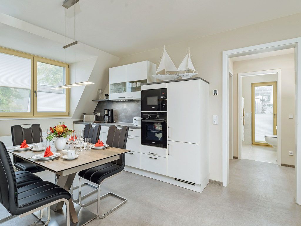 Integral Immobilien: Dein Darß Urlaub Born - voll ausgestattete offene Küche  mit Blick in Richtung Küche und Gäste-WC der Ferienwohnung Hafenkieker