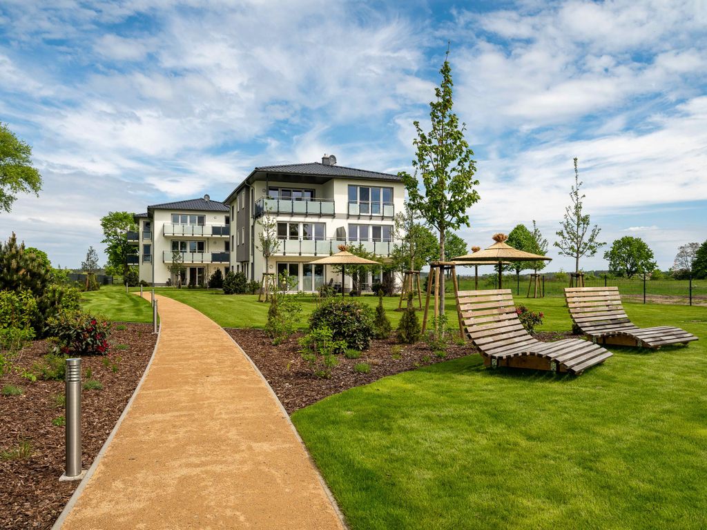 Haffhäuser am Stettiner Haff – helles Ferienhaus mit Balkonen, Gartenweg und Holzliegen auf der Wiese