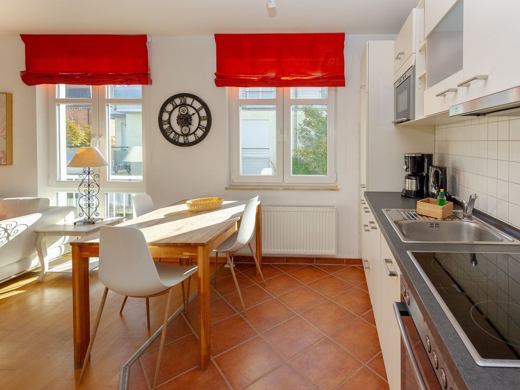 Residenz Prorer Wiek Binz – Küche mit Essplatz und roten Raffrollos