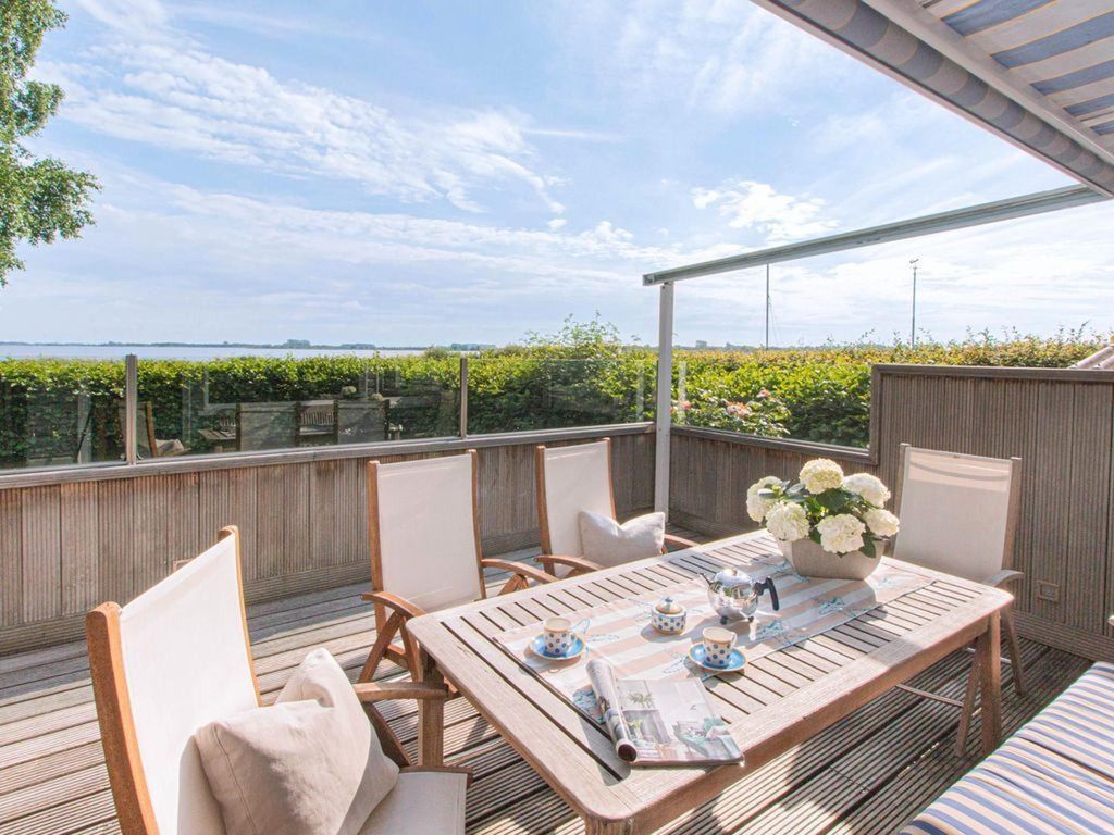 Großzügige Holzterrasse mit Sitzgarnitur, Sonnenschutz und fantastischem Seeblick  das Highlight eines Urlaubs am Großen Meer.