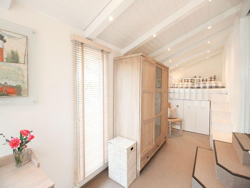 Clever genutzter Schlafbereich unter dem Dach mit Einbauschrank, Kommode und viel Tageslicht  ideal für Paare oder Teenager im Ferienhaus.