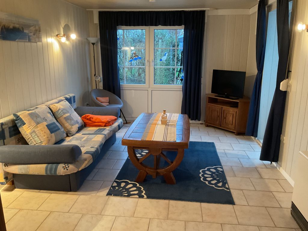 Wohnzimmer mit Schlafcouch und Flachbild-TV