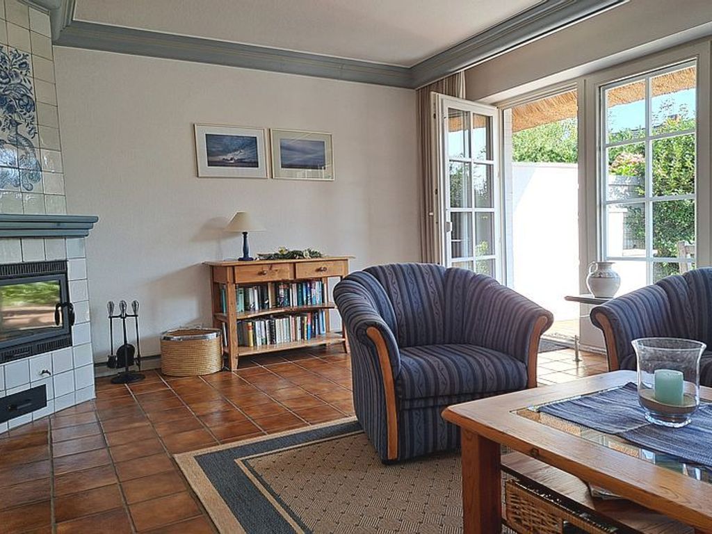 Das helle Wohnzimmer mit Kamin lädt zu einem gemütlichen Miteinander ein.