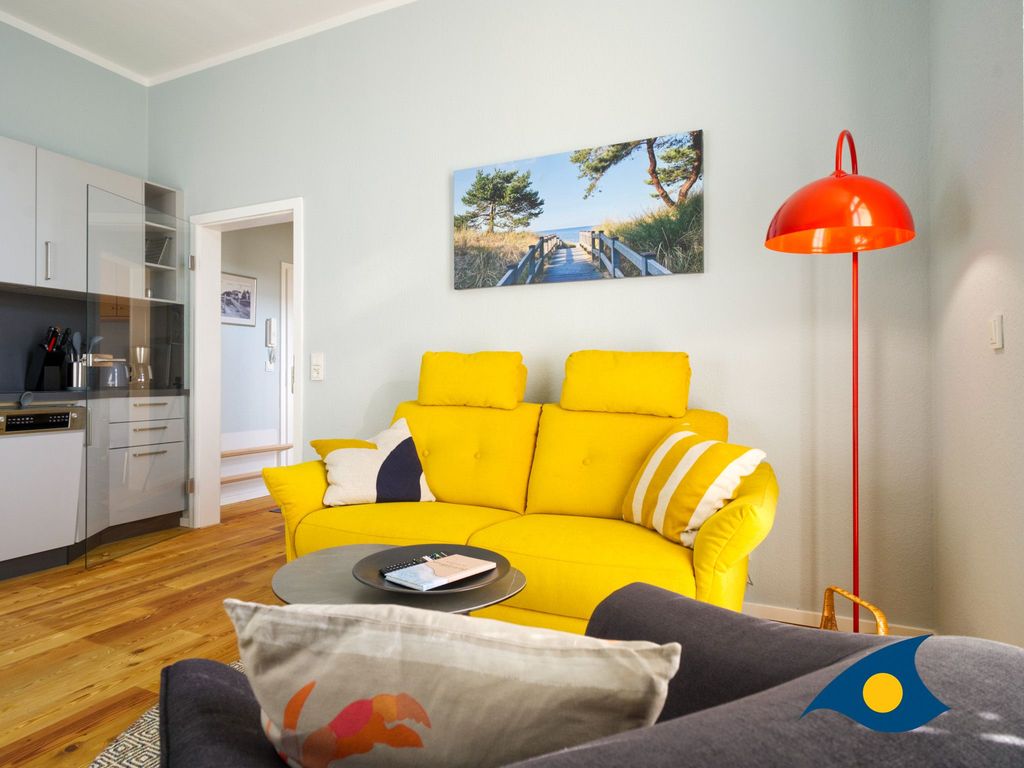 Wohnzimmer mit Küchenzeile, Essbereich und Zugang zum Balkon