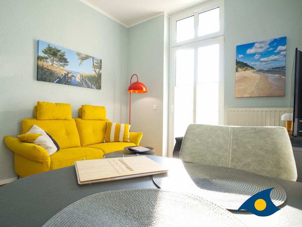 Wohnzimmer mit Küchenzeile, Essbereich und Zugang zum Balkon