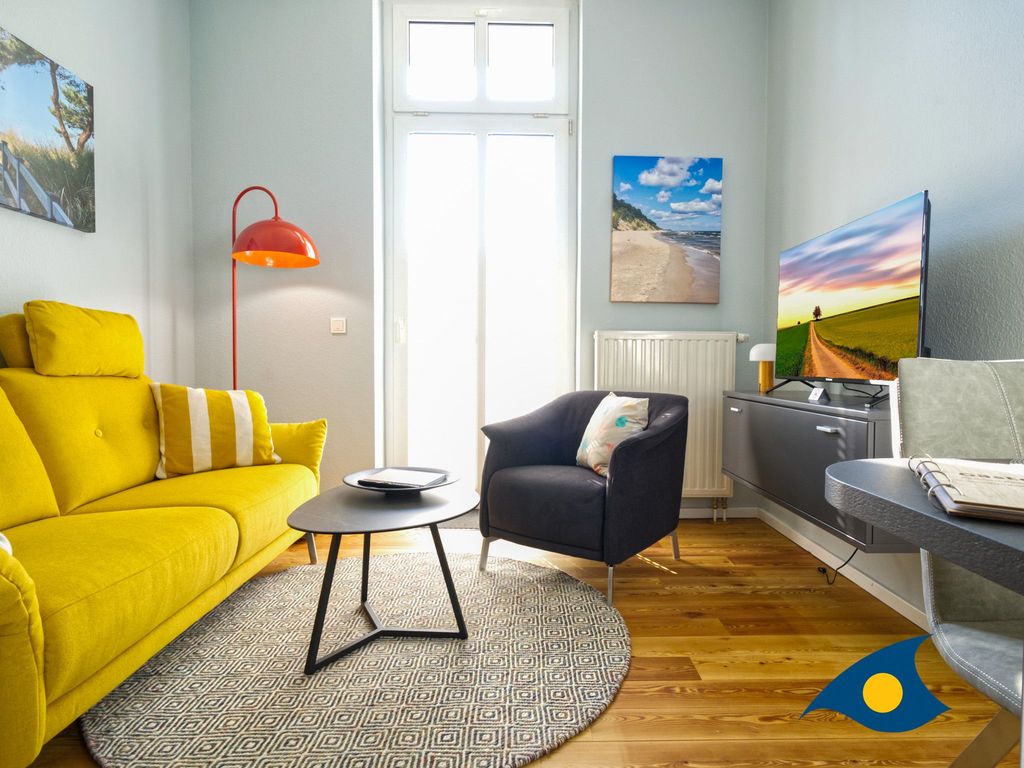 Wohnzimmer mit Küchenzeile, Essbereich und Zugang zum Balkon