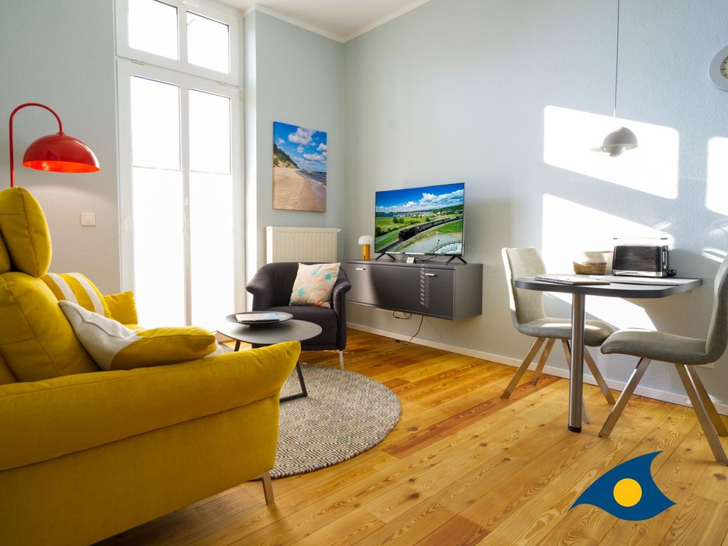 Wohnzimmer mit Küchenzeile, Essbereich und Zugang zum Balkon