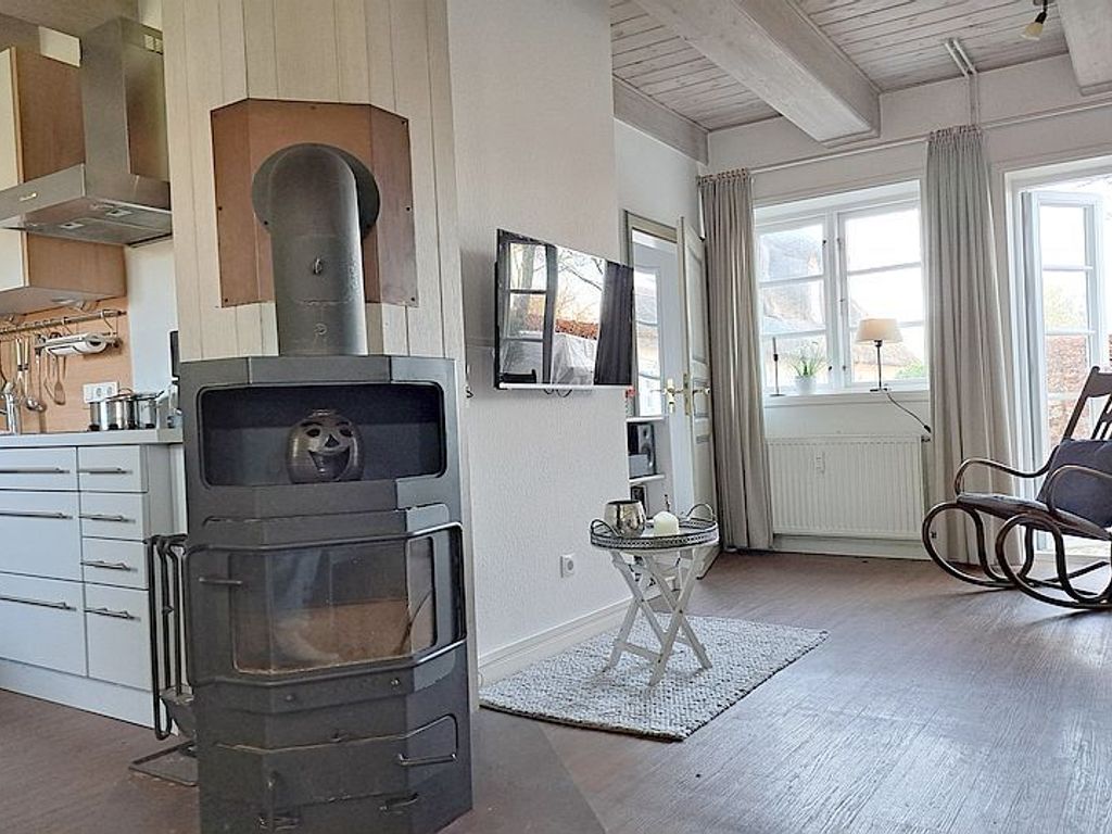 Der Kaminofen lädt zu behaglichen Abenden ein, schöne Accessoires und die Holzbalkendecke wirken behaglich und einladend.