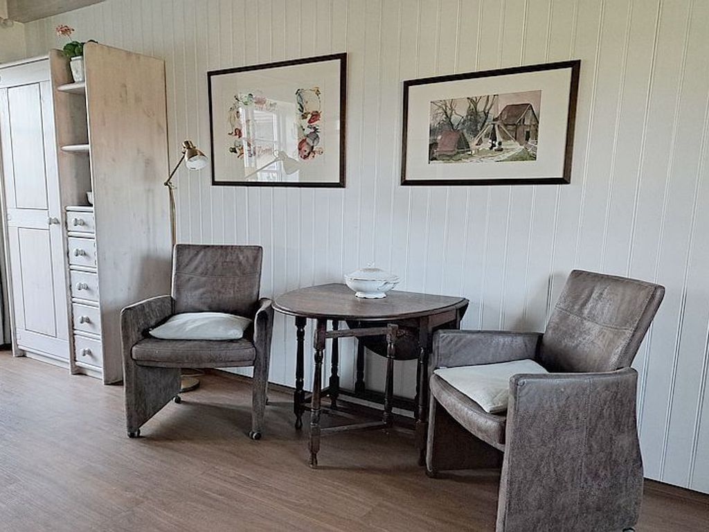 Eine kleine Sitzecke und ein Schaukelstuhl befinden sich vor dem Terrassenfenster.