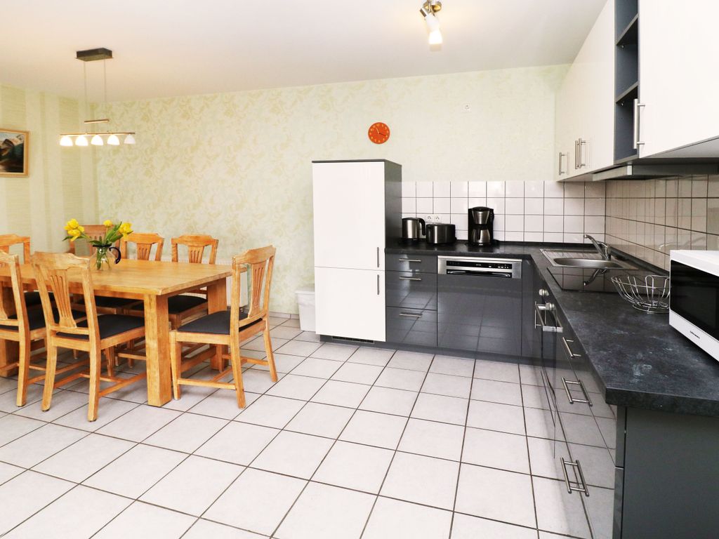 Offene Einbauküche der Ferienwohnung Q03 mit Geschirrspüler, Backofen, Kochfeld, Mikrowelle sowie Kühl- und Gefriermöglichkeit