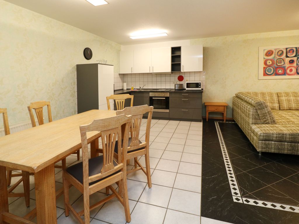 Offener Wohn- und Essbereich der Ferienwohnung Q03 mit gemütlicher Sitzecke, Essplatz und integrierter Einbauküche