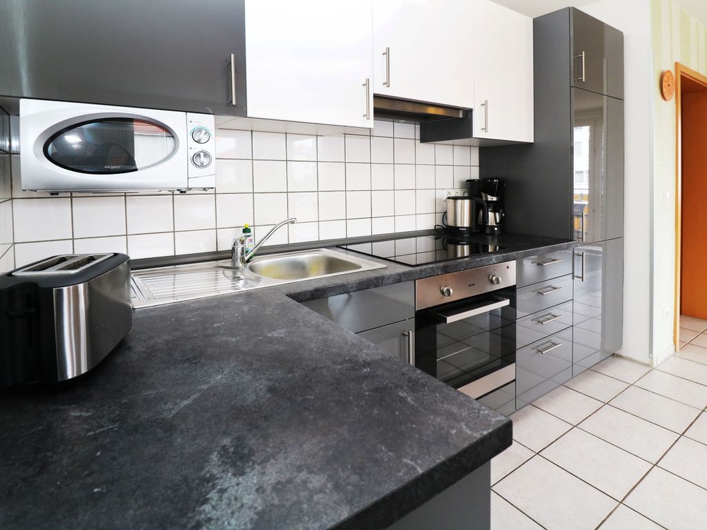 Moderne offene Einbauküche der Ferienwohnung Q04 mit Geschirrspüler, Backofen, Mikrowelle, Kühlschrank und Gefriermöglichkeit