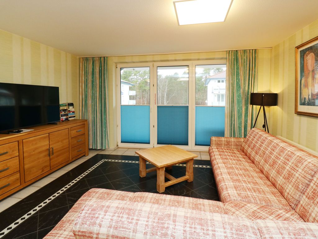 Gemütlicher Wohnbereich der Ferienwohnung Q04 in Karlshagen mit großer Eckcouch und Smart-TV  Streaming-Dienste können mit dem eigenen Benutzerkonto genutzt werden