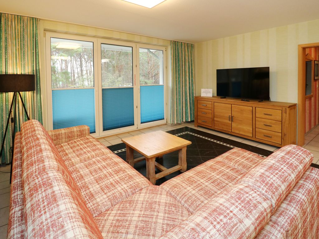 Gemütlicher Wohnbereich der Ferienwohnung Q05 mit Smart-TV, komfortabler Couch und direktem Zugang zum Balkon zur Strandstraße  ideal zum Entspannen nach einem Urlaubstag an der Ostsee.