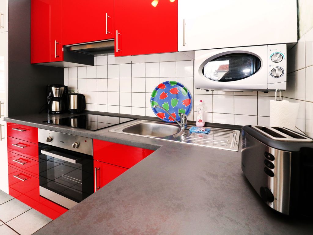 Moderne Einbauküche mit Geschirrspüler, Backofen, Kochfeld, Kühlschrank und allem Wichtigen für die Selbstversorgung.