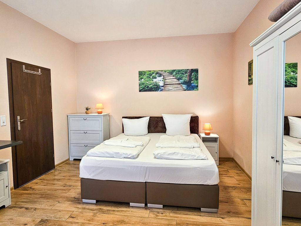 Wohnbereich mit Doppelbett und Küchenzeile sowie Loggia mit Terrassenzugang