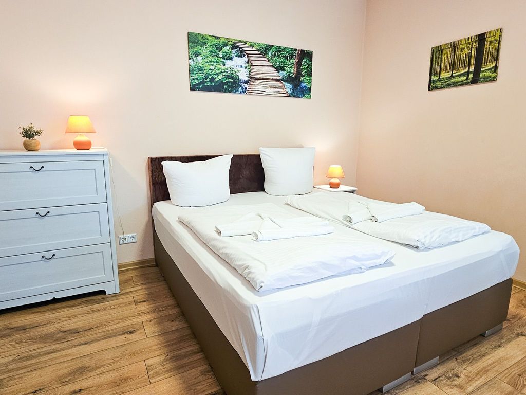 Wohnbereich mit Doppelbett und Küchenzeile sowie Loggia mit Terrassenzugang