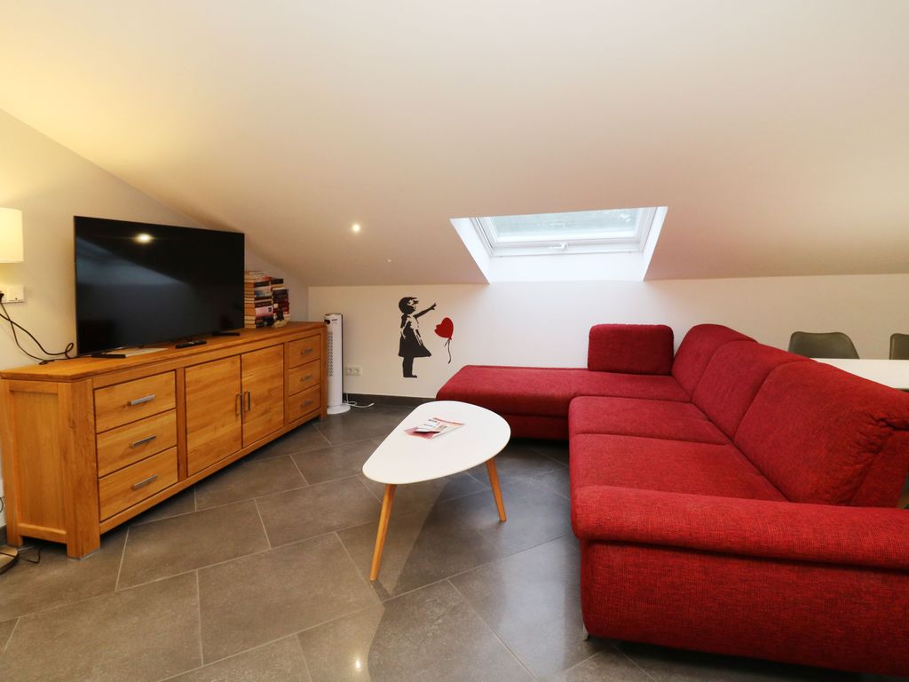 Wohnzimmer mit 55 TV mit teilweise schrägen Dachflächen