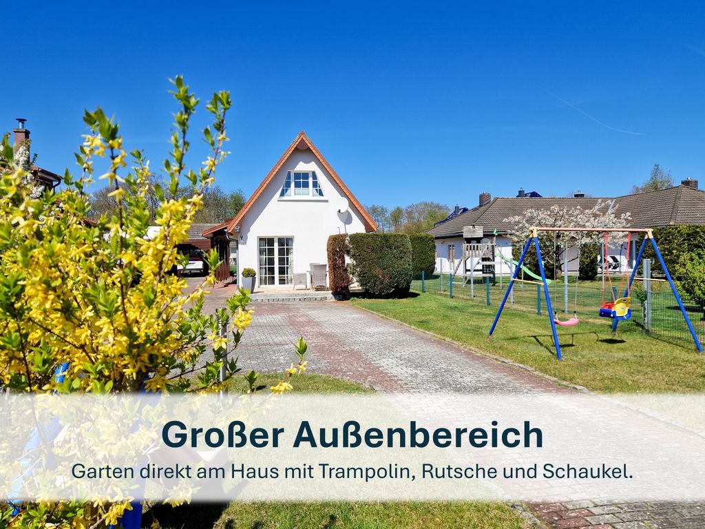 Großer Gartenbereich mit Trampolin, Rutsche und Schaukel.