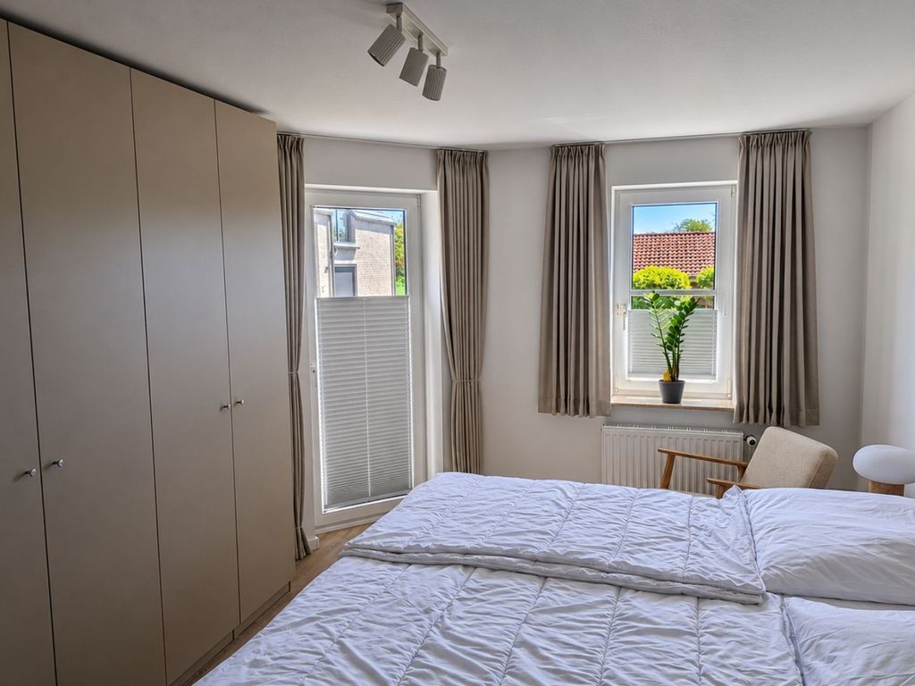 Schlafzimmer mit Doppelbett und Zugang zum Balkon