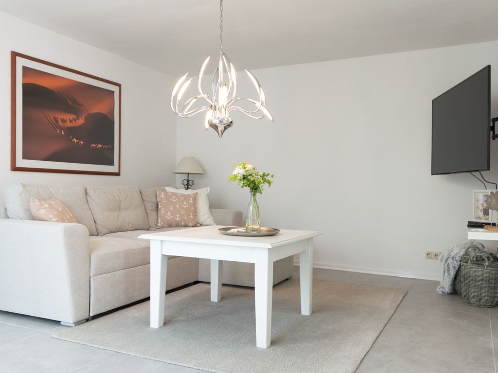 Helles Wohnzimmer mit gemütlichem Sofa, stilvoller Beleuchtung und maritimer Dekoration  perfekt zum Entspannen.